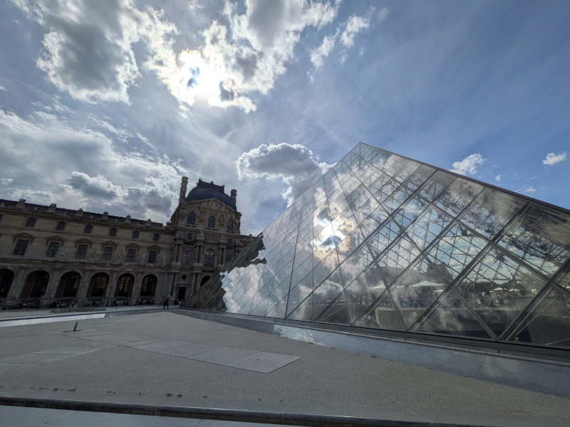 Piramide del Louvre con nuvole e sole: viaggio in camper agosto 2026